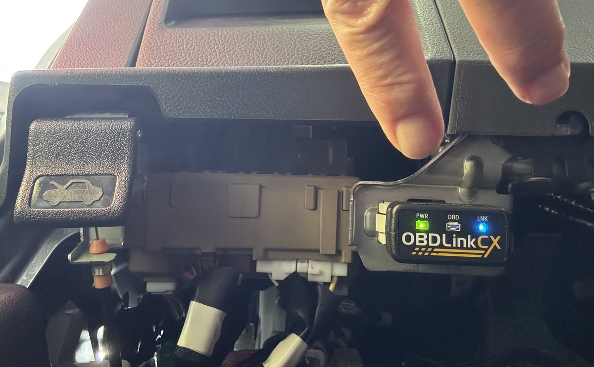 OBDLink CX adapter fully plugged in with power and link lights on